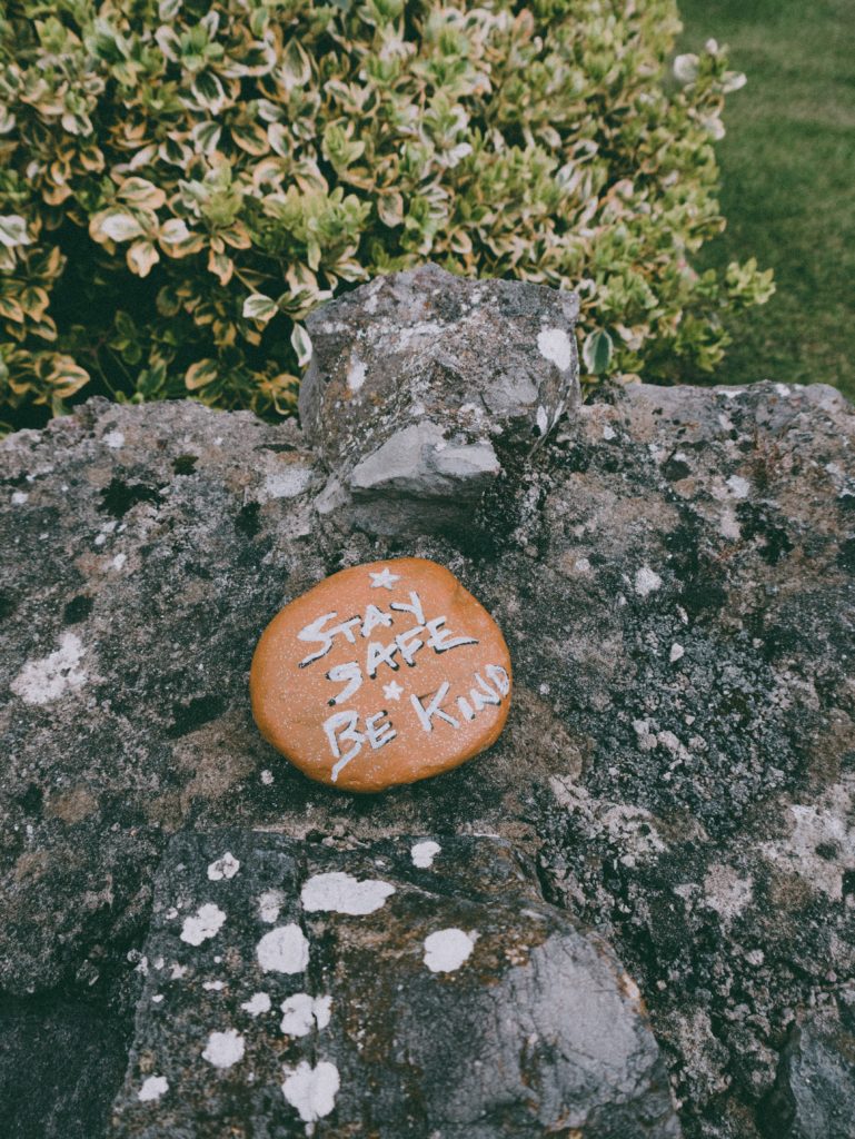 A rock with text that says be safe be kind on it